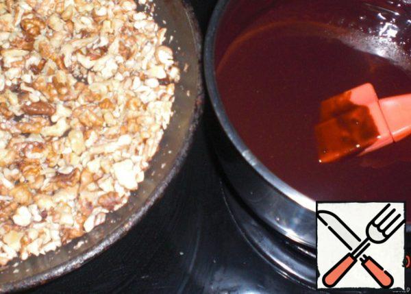 Chop the nuts coarsely and fry in a frying pan. Melt the chocolate with butter.
