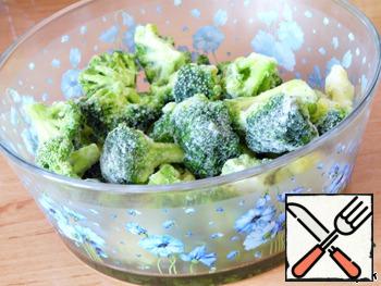 At this time, prepare the filling.
Frozen broccoli spread with dishes for the microwave.