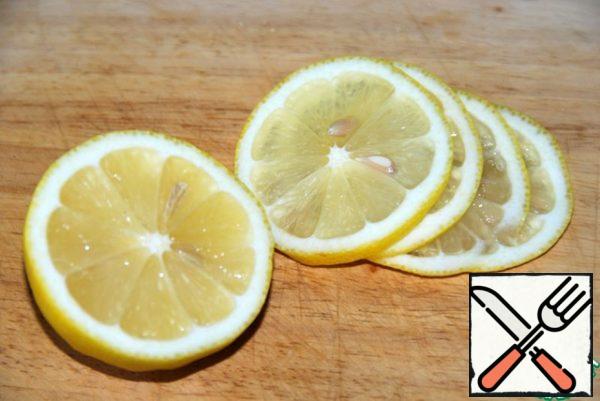 Thinly cut the lemon (enough quarters), you can optionally add an orange.