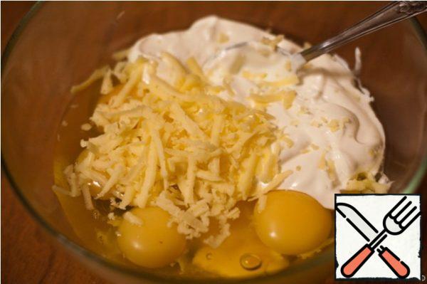 Grate the cheese on a coarse grater. Mix sour cream, eggs and grated cheese.