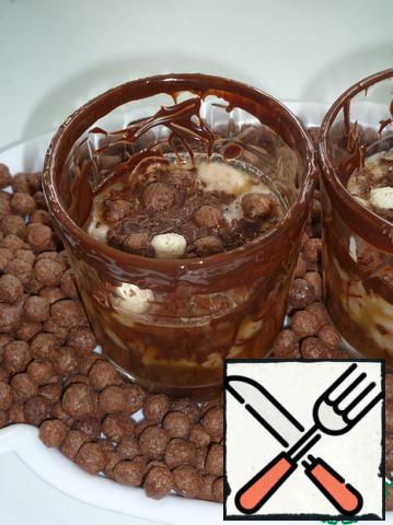Pour tea into a glass, then whipped cream with banana. Sprinkle with grated chocolate and chocolate balls. Good mood!