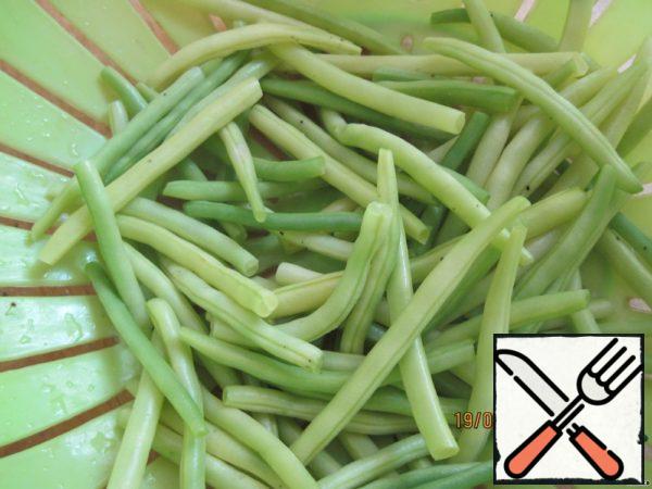 In the meantime, we cut the hard tips of the asparagus beans and boil them in salted water until they are ready. Ready beans cut into 2-3 parts each. Cut tomatoes into small slices.