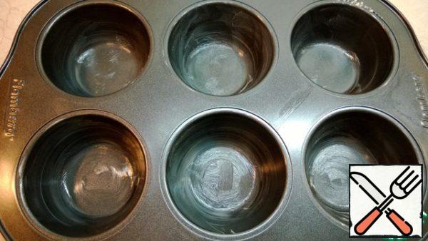 Grease the molds with butter. Put one tablespoon of dough in each.
