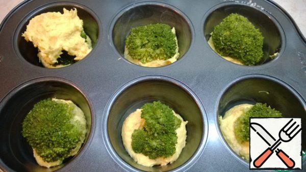 Remove the broccoli from the water and dry it on a paper towel.
Select the inflorescences of the desired size. Put each inflorescence on the dough and make a recess, pressing lightly.
Put 1 tablespoon of dough on top of each broccoli inflorescence. The dough turns out to be viscous, so moisten a little spoon with water and shape it so as to cover the broccoli.