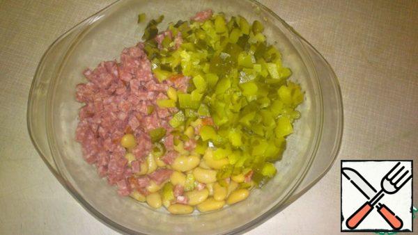 Sausage and pickles cut into cubes and mix with canned beans.

