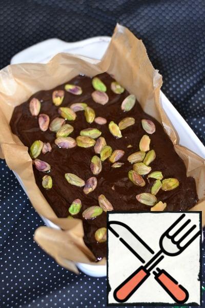 Prepare a baking mold. It can be any: rectangular, square or round. Size - about 22-24 cm in diameter. Cover it with baking paper.
Lay out half test, then pistachios, then the second half of test. 