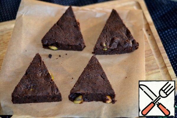 Bake brownies for 30 minutes at a temperature of 150 degrees. Remove, cool slightly, remove the paper, cut into triangles.
Insert the tube into the brownie base.

