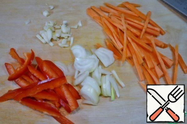 Onions, carrots, peppers and garlic cut into thin strips.