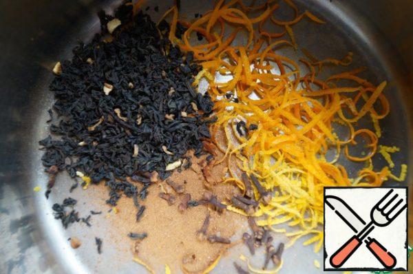 Remove the zest from 1 orange, 1 lemon and 1 tangerine. Put the zest in a saucepan, add cloves, cinnamon and tea.
