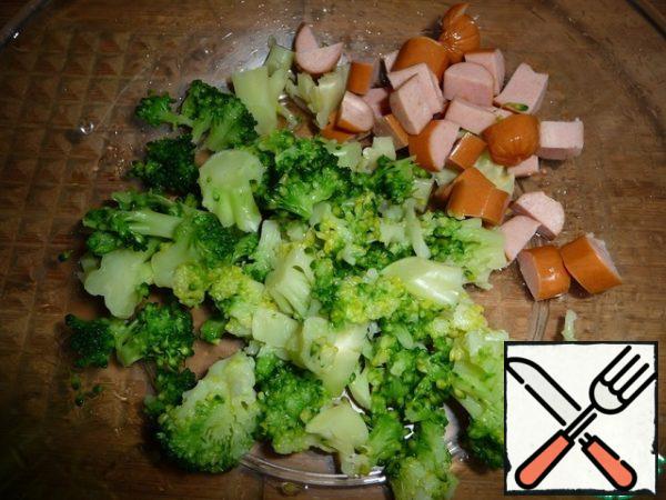 Broccoli and sausage cut into pieces.
