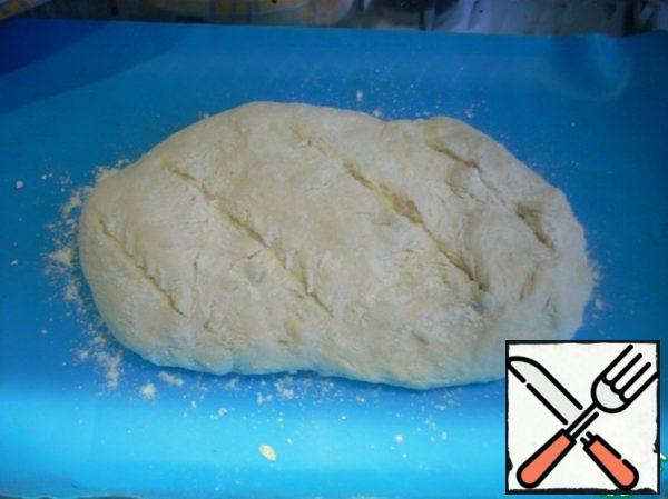 Let's make shallow cuts on our future bread. Sprinkle with flour on top. You can give the bread a bit to go, about 15-20 minutes.
At the bottom of the oven put a container of water. Bake for 40-50 minutes until Golden brown.