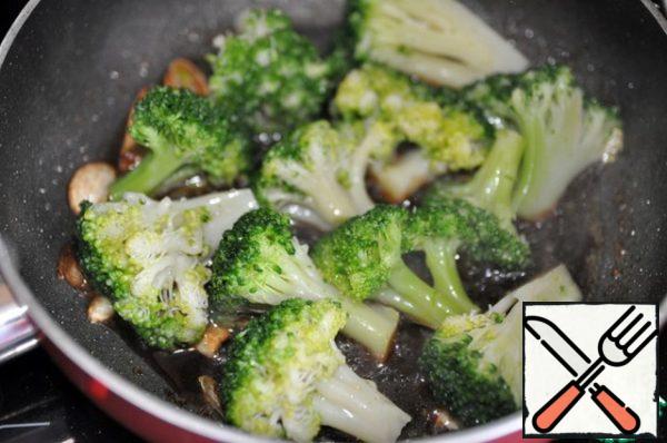 Put broccoli in the sauce and fry, stirring constantly, on maximum heat for 2 minutes. Inflorescences should be completely in the sauce.