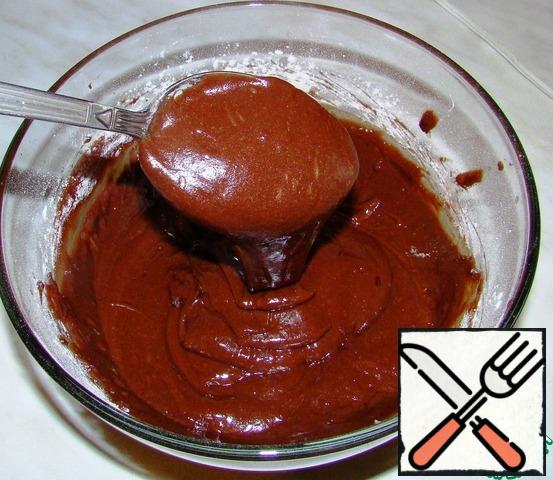 Add the sifted flour with cocoa powder and baking powder. Mix well and get the dough here is such a consistency.