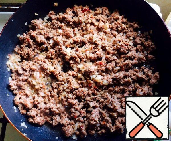 While the dough is resting, prepare the filling. Fry on a drop of vegetable (and better-olive) oil our minced meat mixed with finely chopped onions, garlic, spices (to your taste) passed through the press. Meat is better to take low-fat: veal or chicken.