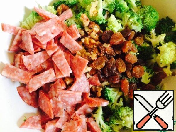 Put the broccoli, walnuts, raisins and thinly sliced salami in a bowl.
