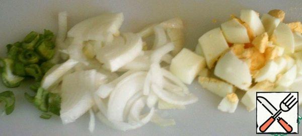 Peel the onion and cut it into half rings.
Cut the eggs into cubes.
