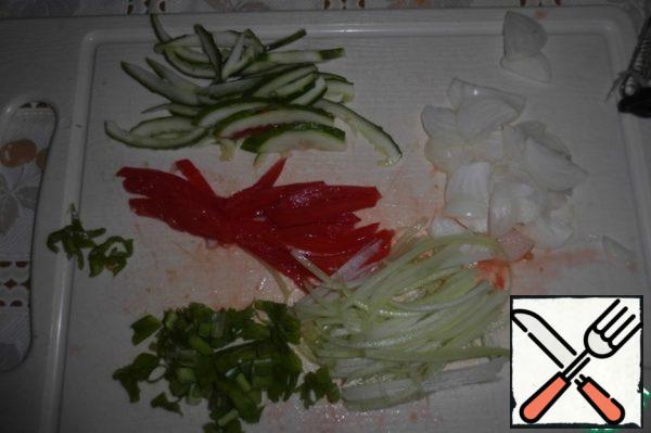 Wash one tomato, half a cucumber and green onions.
Tomato and cucumber remove the seeds, peel the shallots.
All cut into thin strips.
Greens of a celery wash, cut noodles.
Chilli peppers cut into pieces.