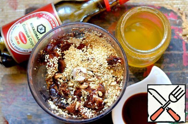 In the bowl of a blender combine sesame seeds, sunflower seeds, dates, honey, soy sauce (sweet).