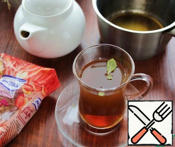 In heated heat-resistant glasses pour sugar syrup and tea, add a leaf of mint.