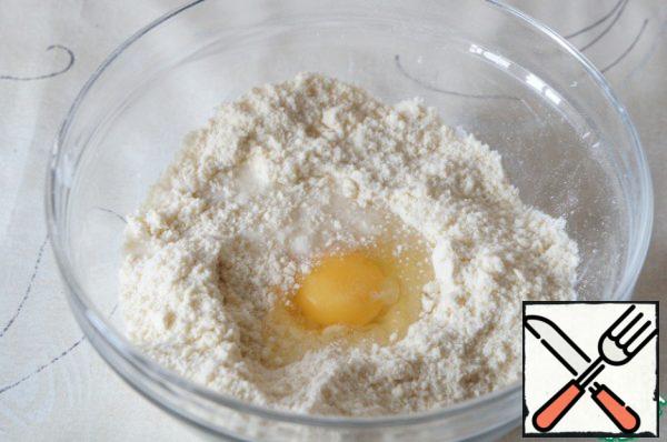 Sift the flour. Add the butter, cut into pieces, and salt. RUB hands into a homogeneous crumb. Drive the egg and pour water.