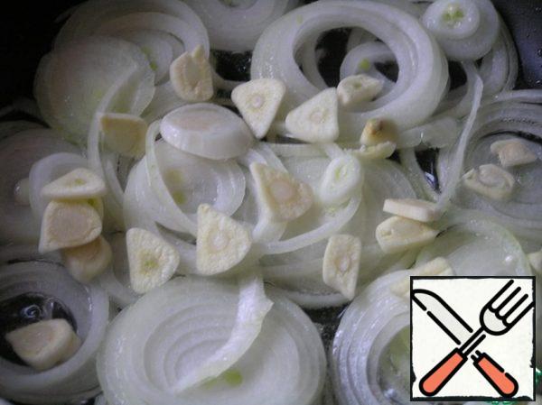 Cut the onion into rings, fry in vegetable oil with chopped garlic over medium heat until soft.
