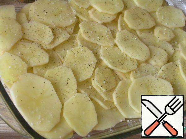 Form for baking grease with vegetable oil. Potatoes cut into thin circles, put half in the form. Salt and pepper.