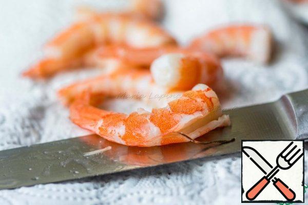 Peel the shrimp from the shell, make an incision on the back and remove the dark streak. Cut the shrimp into cubes.
