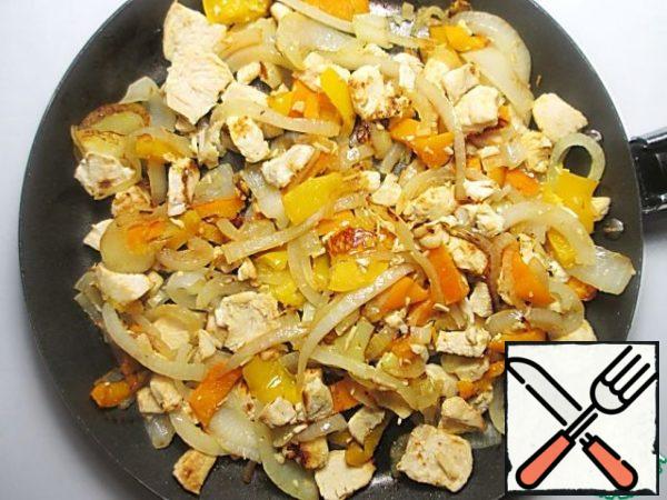 Add, if necessary, on the same pan a little vegetable oil, fry the onion, then add the bell pepper and pieces of chicken, fry a little more.