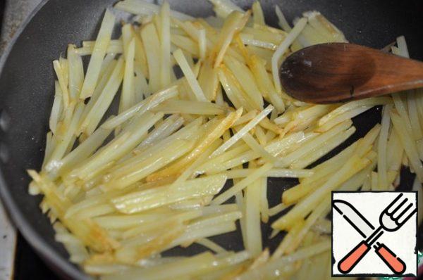 It is better to cook, of course, in a wok. But you can take an ordinary frying pan. Fry the potatoes in preheated oil until golden brown (about 5 minutes). If you cook a lot, then fry in portions, since potatoes give off a lot of moisture and are poorly fried. Transfer the finished potatoes from the pan to a plate.
