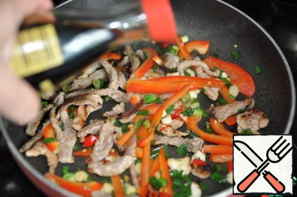 Add soy sauce to pork with vegetables and mix.