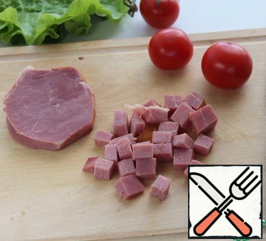 Cut the ham into cubes, cut cherry tomatoes into quarters, tear the lettuce leaves with your hands. 