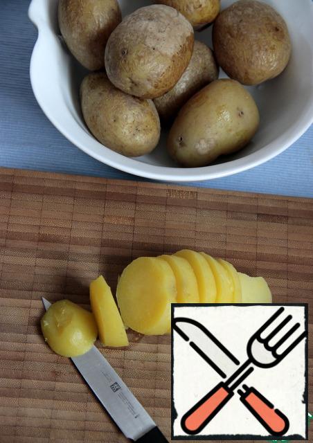 Boil the potatoes in their uniforms for 20 minutes, strain, pour cold water, then it was easier to peel. Let the potatoes cool. Peel and slice.