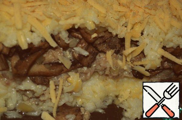 After greasing the pan with oil, spread in layers:
half of the rice, the whole minced meat, mushrooms with onion and pour the rice.
Sprinkle with the remaining cheese, mixed with breadcrumbs.
Put in oven. At 180 degrees bake for 30 minutes.