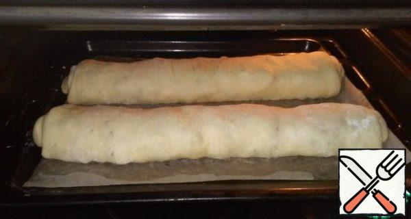 Cover the baking sheet with baking paper and put the rolls on it. Preheat the oven to 180 degrees and send the future strudel into it for 30 minutes. The readiness of the dish can be easily determined by the formation of a golden brown crust. Brush the top with a piece of butter.

