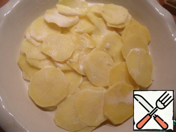 Heat-resistant form of grease with butter, using skimmer put it in an even layer of potatoes.