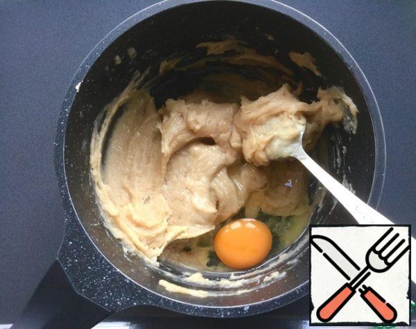 Once the mixture has become homogeneous, remove it from the heat, allow to cool for 10 minutes and in turn stir in the dough 2 eggs. First, mix one egg, as soon as it is fully included in the dough, add the second egg and just as carefully mix it into the dough.
Eggs are fine for interfering with a spoon, but if you want you can use mixer.