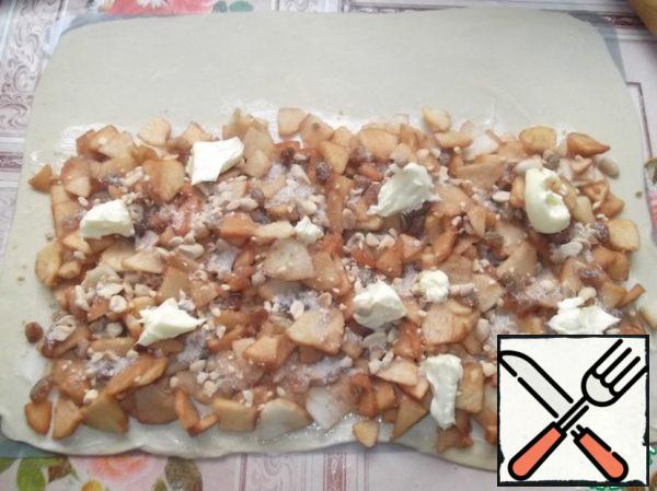 Spread the apples, raisins, nuts evenly, sprinkle with sugar and cinnamon and distribute the remaining butter.
