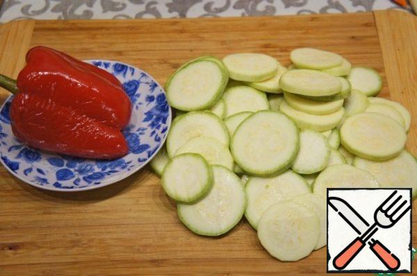 Zucchini wash, dry and cut into very thin, almost like chips, circles. Pepper cut into lengthwise strips or wide.