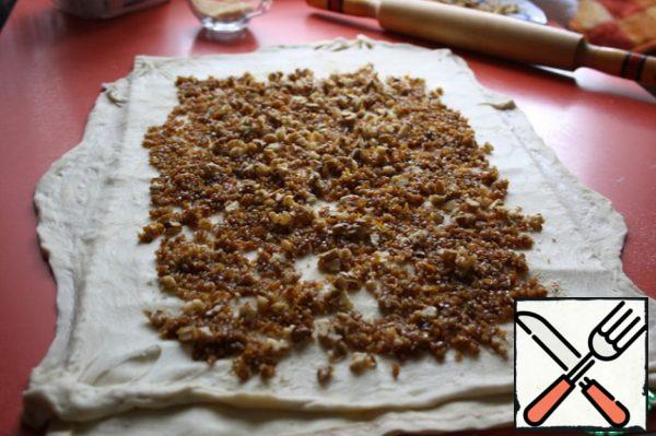 Now smooth out the bulgur filling for the dough. And gently roll it into a roll with a towel.
