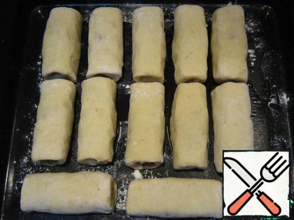 Grease the baking sheet with vegetable oil, sprinkle with flour and lay out the rolls.
