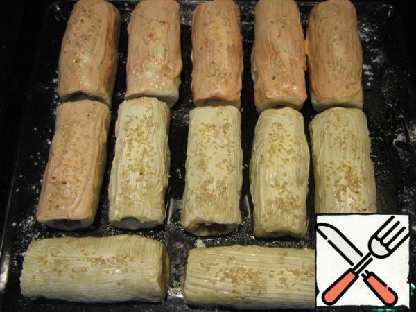 I smeared half of the rolls with mayonnaise, the other half with mayonnaise mixed with ketchup. Sprinkle with sesame seeds. Bake at 200 degrees for 25 minutes.
