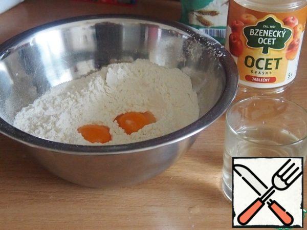 Mix flour with salt, add yolks, 120 ml of warm water with a spoon of vinegar.