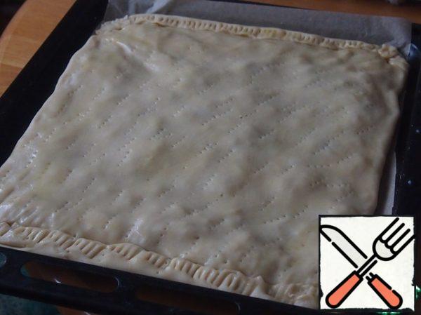Lay out the second rectangle of dough to take the edges, prick the dough tightly with a fork, put it in a preheated oven and bake at 180 degrees for about 20-25 minutes. Then take the pie out of the oven, quickly brush with the protein whipped with a fork, sprinkle the remaining almonds on top and put it back in the oven for 10 minutes.

