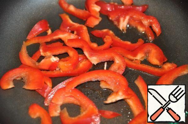 In the same pan fry (adding more oil) bell pepper, cut into strips.
Cook the pepper over high heat for about 1 minute, stirring constantly. The pepper should remain half-baked. Remove the pepper on a plate.
