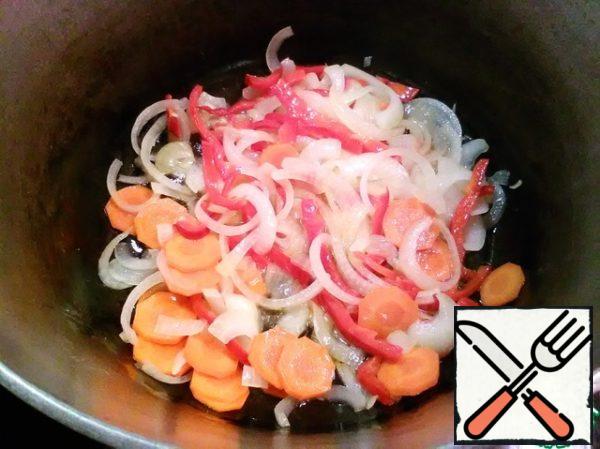 Add oil to the cauldron and heat, spread the onion with carrots and pepper. Cover and simmer until they soften.