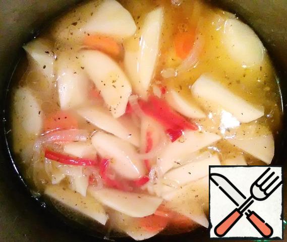 Spread on top of potatoes.
So that the potatoes do not boil, we immediately salt it.
Add a mixture of peppers, stir and pour boiling water.
The water level is about 2 cm above the potato.
Cover the cauldron with a lid and leave to cook on low heat.