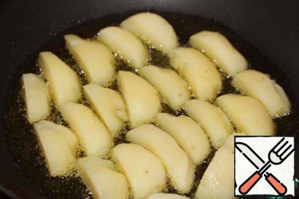 Heat vegetable oil in a frying pan and quickly fry the potato slices until Golden brown.