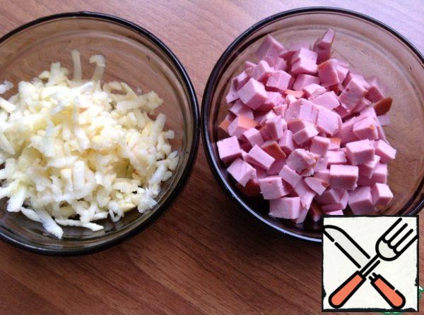 Peel the apple and grate it on a coarse grater. Cut the sausage into small cubes.
