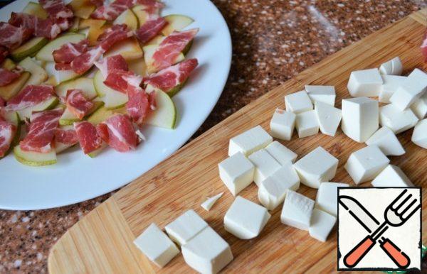 Cut the cheese into cubes. Roll half of the cheese in poppy seeds, the second half in fried sesame seeds.
