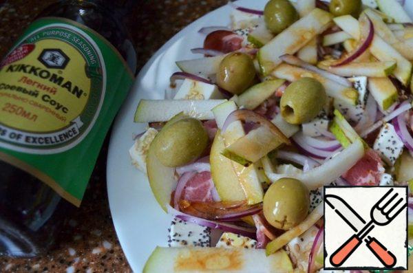 Peel the onion, cut it into feathers and put it on a platter. Cut the remaining part of the pear into thin strips, spread olives on top.
